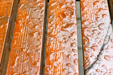 Tahta bir bankta yağmur damlaları. Yakın plan..