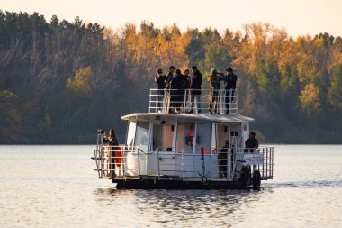 Petropavlovsk, Kazakistan - 14 Eylül 2019: nehirde beyaz zevk gemisi. Geminin güvertesinde insanlar var. Nehir ve ağaçların sonbahar manzarası.