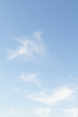 Mavi gökyüzünde beyaz ince bulutlar, açık gündüz gökyüzü.