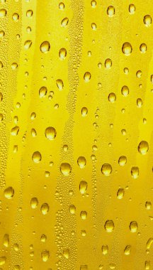 Cam su damlaları, sarı arka plan bira, buğulu arka plan.