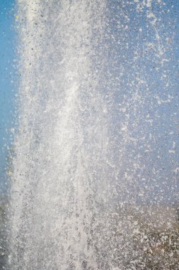 Mavi gökyüzüne karşı Su Çeşmesi sprey. Su sıçramaları odak dışında.