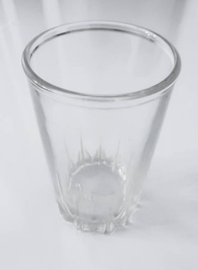 Beyaz zemin üzerinde boş cam bardak, üst görünüm.