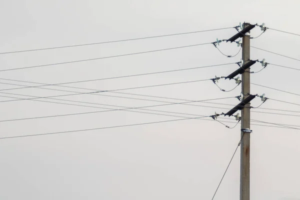 Electric pole with lamp of wires against the sky.