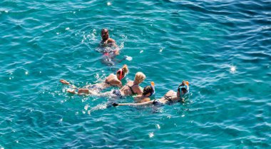 Sharm El Sheikh, Mısır - 1 Şubat 2020: Deniz kenarında yoğun bir yaz tatili. Güneşli bir günde insanlar denizde ve sahilde, güneşleniyorlar, yüzüyorlar.