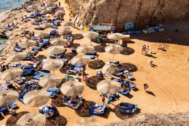 Sharm El Sheikh, Mısır - 1 Şubat 2020. Deniz kenarındaki plaj salonları, şemsiyeler, insanlar dinleniyor. Deniz kenarında yoğun bir yaz tatili. Güneşli bir gün, güneş banyosu, yüzme.