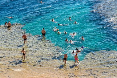 Sharm El Sheikh, Mısır - 1 Şubat 2020: Deniz kenarında yoğun bir yaz tatili. Güneşli bir günde insanlar denizde ve sahilde, güneşleniyorlar, yüzüyorlar.