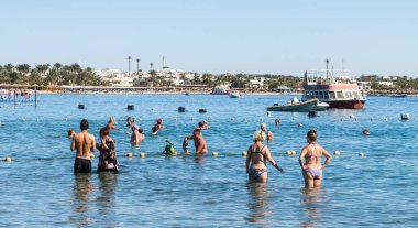 Sharm El Sheikh, Mısır - 1 Şubat 2020: Deniz kenarında yoğun bir yaz tatili. Güneşli bir günde insanlar denizde ve sahilde, güneşleniyorlar, yüzüyorlar.