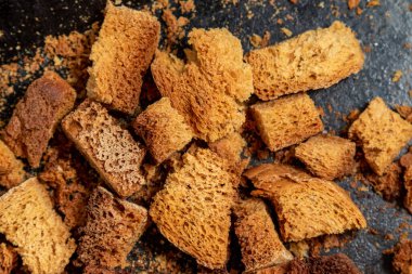 Burnt bread crackers. The texture of the slices of dry rye bread. Crackers or rusks made from homemade white bread are baked in the oven in close-up. Cooking croutons. clipart