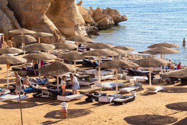 Sharm El Sheikh, Mısır - 1 Şubat 2020: Deniz kenarında yoğun bir yaz tatili. Güneşli bir günde insanlar denizde ve sahilde, güneşleniyorlar, yüzüyorlar.