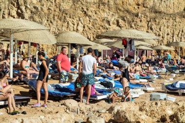 Sharm El Sheikh, Mısır - 1 Şubat 2020. Deniz kenarındaki plaj salonları, şemsiyeler, insanlar dinleniyor. Deniz kenarında yoğun bir yaz tatili. Güneşli bir gün, güneş banyosu, yüzme.