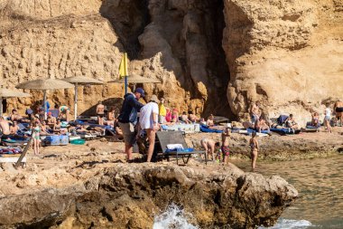 Sharm El Sheikh, Mısır - 1 Şubat 2020: Deniz kenarında yoğun bir yaz tatili. Güneşli bir günde insanlar denizde ve sahilde, güneşleniyorlar, yüzüyorlar.