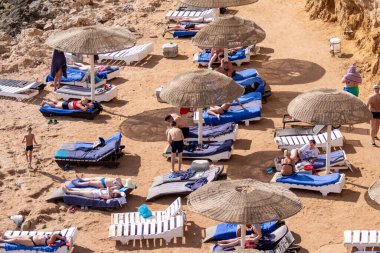 Sharm El Sheikh, Mısır - 1 Şubat 2020. Deniz kenarındaki plaj salonları, şemsiyeler, insanlar dinleniyor. Deniz kenarında yoğun bir yaz tatili. Güneşli bir gün, güneş banyosu, yüzme.