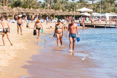 Sharm El Sheikh, Mısır - 1 Şubat 2020: Deniz kenarında yoğun bir yaz tatili. Güneşli bir günde insanlar denizde ve sahilde, güneşleniyorlar, yüzüyorlar.