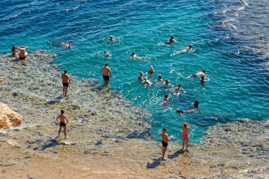 Sharm El Sheikh, Mısır - 1 Şubat 2020: Deniz kenarında yoğun bir yaz tatili. Güneşli bir günde insanlar denizde ve sahilde, güneşleniyorlar, yüzüyorlar.