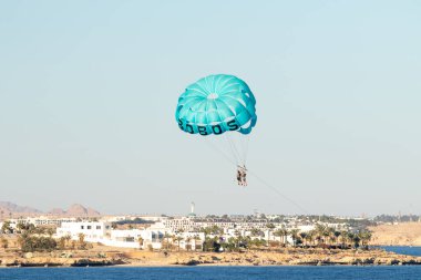 Sharm El Sheikh, Mısır - 27 Ocak 2020: Denizdeki mavi gökyüzüne karşı bir paraşüt. Sıcak ve güneşli bir günde deniz aktiviteleri.