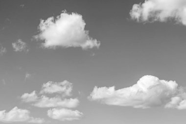 Siyah-beyaz fotoğraf, gökyüzünde beyaz desenli kabarık bulutlar.