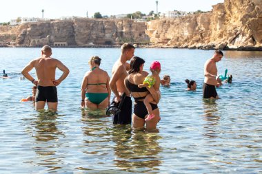 Sharm El Sheikh, Mısır - 1 Şubat 2020: Deniz kenarında yoğun bir yaz tatili. Güneşli bir günde insanlar denizde ve sahilde, güneşleniyorlar, yüzüyorlar.