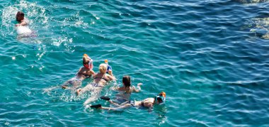 Sharm El Sheikh, Mısır - 1 Şubat 2020: Deniz kenarında yoğun bir yaz tatili. Güneşli bir günde insanlar denizde ve sahilde, güneşleniyorlar, yüzüyorlar.