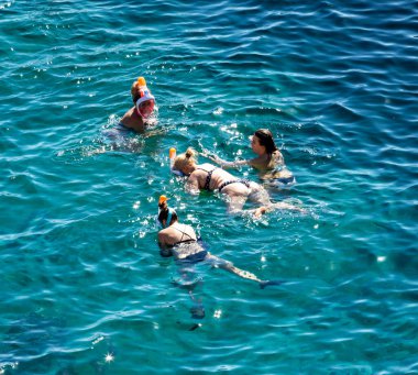 Sharm El Sheikh, Mısır - 1 Şubat 2020: Deniz kenarında yoğun bir yaz tatili. Güneşli bir günde insanlar denizde ve sahilde, güneşleniyorlar, yüzüyorlar.