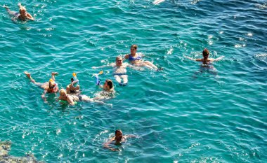 Sharm El Sheikh, Mısır - 1 Şubat 2020: Deniz kenarında yoğun bir yaz tatili. Güneşli bir günde insanlar denizde ve sahilde, güneşleniyorlar, yüzüyorlar.