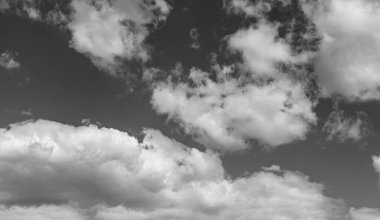 Siyah-beyaz fotoğraf, gökyüzünde beyaz desenli kabarık bulutlar.