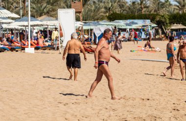 Sharm El Sheikh, Mısır - 1 Şubat 2020. Deniz kenarındaki plaj salonları, şemsiyeler, insanlar dinleniyor. Deniz kenarında yoğun bir yaz tatili. Güneşli bir gün, güneş banyosu, yüzme.