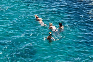 Sharm El Sheikh, Mısır - 1 Şubat 2020: Deniz kenarında yoğun bir yaz tatili. Güneşli bir günde insanlar denizde ve sahilde, güneşleniyorlar, yüzüyorlar.