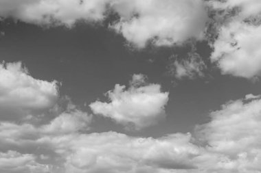 Siyah-beyaz fotoğraf, gökyüzünde beyaz desenli kabarık bulutlar.