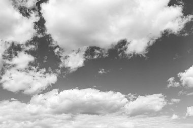 Siyah-beyaz fotoğraf, gökyüzünde beyaz desenli kabarık bulutlar.