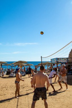 Sharm El Sheikh, Mısır - 4 Şubat 2020. İnsanlar plajda top ile voleybol oynuyorlar. Deniz kenarında yoğun bir yaz tatili. Güneşli bir gün.