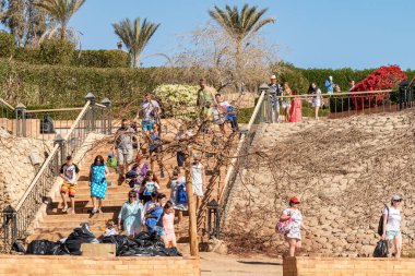 Sharm El Sheikh, Mısır - 5 Şubat 2020: Kızlar ve kadınlar, erkekler deniz kıyısında, sıcak güneşli bir gün. Deniz kenarında yoğun bir yaz tatili..