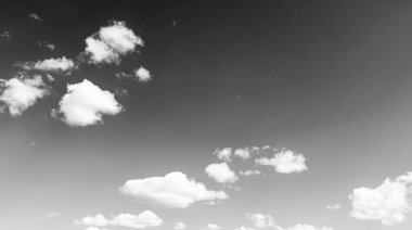 Siyah-beyaz fotoğraf, gökyüzünde beyaz desenli kabarık bulutlar.