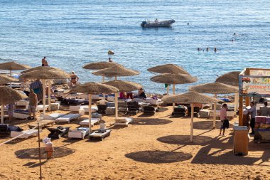 Sharm El Sheikh, Mısır - 1 Şubat 2020: Deniz kenarında yoğun bir yaz tatili. Güneşli bir günde insanlar denizde ve sahilde, güneşleniyorlar, yüzüyorlar.