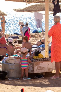 Sharm El Sheikh, Mısır - 1 Şubat 2020. Deniz kenarındaki plaj salonları, şemsiyeler, insanlar dinleniyor. Deniz kenarında yoğun bir yaz tatili. Güneşli bir gün, güneş banyosu, yüzme.