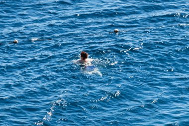 Sharm El Sheikh, Mısır - 1 Şubat 2020: Deniz kenarında yoğun bir yaz tatili. Güneşli bir günde insanlar denizde ve sahilde, güneşleniyorlar, yüzüyorlar.