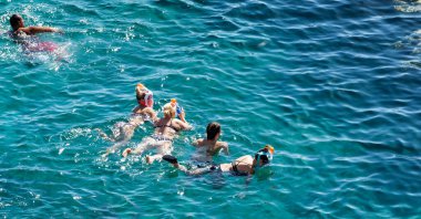 Sharm El Sheikh, Mısır - 1 Şubat 2020: Deniz kenarında yoğun bir yaz tatili. Güneşli bir günde insanlar denizde ve sahilde, güneşleniyorlar, yüzüyorlar.