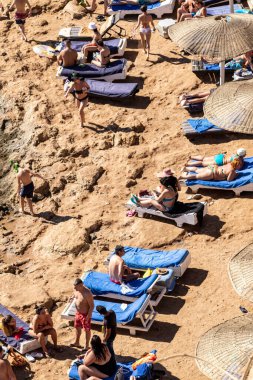 Sharm El Sheikh, Mısır - 1 Şubat 2020. Deniz kenarındaki plaj salonları, şemsiyeler, insanlar dinleniyor. Deniz kenarında yoğun bir yaz tatili. Güneşli bir gün, güneş banyosu, yüzme.