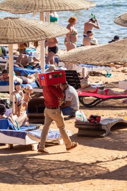 Sharm El Sheikh, Mısır - 1 Şubat 2020. Deniz kenarındaki plaj salonları, şemsiyeler, insanlar dinleniyor. Deniz kenarında yoğun bir yaz tatili. Güneşli bir gün, güneş banyosu, yüzme.