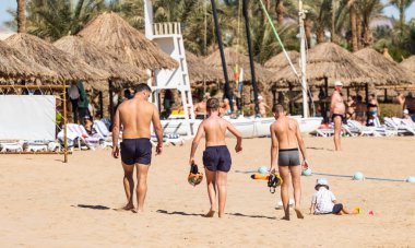 Sharm El Sheikh, Mısır - 1 Şubat 2020: Deniz kenarında yoğun bir yaz tatili. Güneşli bir günde insanlar denizde ve sahilde, güneşleniyorlar, yüzüyorlar.