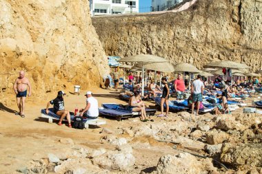 Sharm El Sheikh, Mısır - 1 Şubat 2020. Deniz kenarındaki plaj salonları, şemsiyeler, insanlar dinleniyor. Deniz kenarında yoğun bir yaz tatili. Güneşli bir gün, güneş banyosu, yüzme.