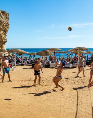 Sharm El Sheikh, Mısır - 4 Şubat 2020. İnsanlar plajda top ile voleybol oynuyorlar. Deniz kenarında yoğun bir yaz tatili. Güneşli bir gün.