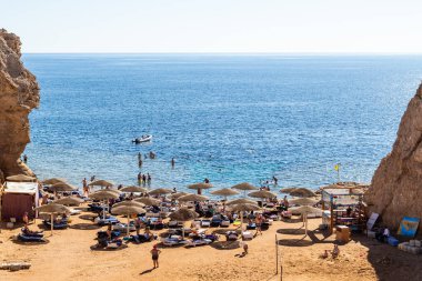Sharm El Sheikh, Mısır - 1 Şubat 2020. Deniz kenarındaki plaj salonları, şemsiyeler, insanlar dinleniyor. Deniz kenarında yoğun bir yaz tatili. Güneşli bir gün, güneş banyosu, yüzme.