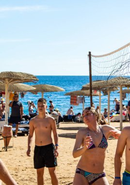 Sharm El Sheikh, Mısır - 4 Şubat 2020. İnsanlar plajda top ile voleybol oynuyorlar. Deniz kenarında yoğun bir yaz tatili. Güneşli bir gün.