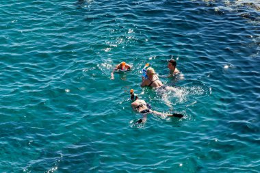 Sharm El Sheikh, Mısır - 1 Şubat 2020: Deniz kenarında yoğun bir yaz tatili. Güneşli bir günde insanlar denizde ve sahilde, güneşleniyorlar, yüzüyorlar.