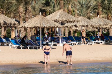 Sharm El Sheikh, Mısır - 1 Şubat 2020: Deniz kenarında yoğun bir yaz tatili. Güneşli bir günde insanlar denizde ve sahilde, güneşleniyorlar, yüzüyorlar.