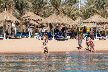 Sharm El Sheikh, Mısır - 1 Şubat 2020: Deniz kenarında yoğun bir yaz tatili. Güneşli bir günde insanlar denizde ve sahilde, güneşleniyorlar, yüzüyorlar.