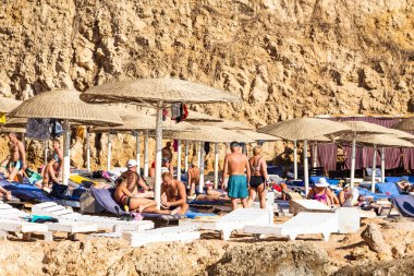 Sharm El Sheikh, Mısır - 1 Şubat 2020. Deniz kenarındaki plaj salonları, şemsiyeler, insanlar dinleniyor. Deniz kenarında yoğun bir yaz tatili. Güneşli bir gün, güneş banyosu, yüzme.