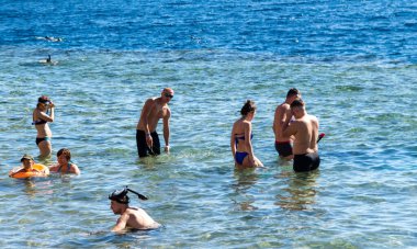 Sharm El Sheikh, Mısır - 1 Şubat 2020: Deniz kenarında yoğun bir yaz tatili. Güneşli bir günde insanlar denizde ve sahilde, güneşleniyorlar, yüzüyorlar.