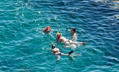 Sharm El Sheikh, Mısır - 1 Şubat 2020: Deniz kenarında yoğun bir yaz tatili. Güneşli bir günde insanlar denizde ve sahilde, güneşleniyorlar, yüzüyorlar.