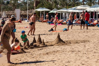 Sharm El Sheikh, Mısır - 1 Şubat 2020. Deniz kenarındaki plaj salonları, şemsiyeler, insanlar dinleniyor. Deniz kenarında yoğun bir yaz tatili. Güneşli bir gün, güneş banyosu, yüzme.